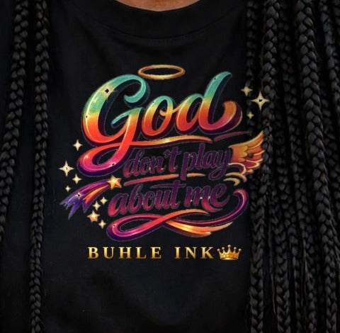 Close-up of the God Don't Play About Me print on the black tee, worn.